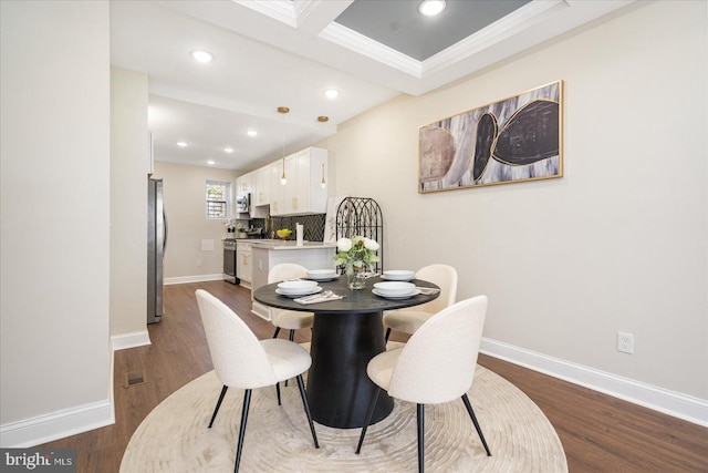 dining area featuring ornamental molding and dark wood-type flooring