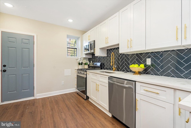 kitchen with stainless steel appliances, dark hardwood / wood-style flooring, decorative backsplash, light stone countertops, and white cabinetry