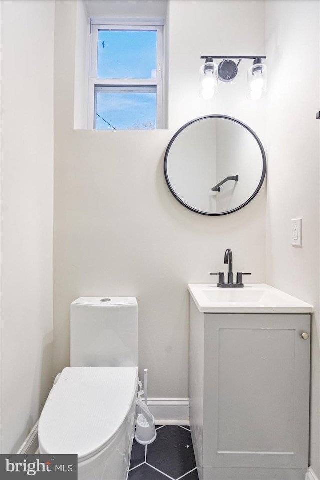 bathroom with toilet, vanity, and tile patterned floors