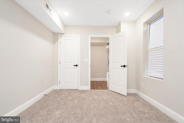 unfurnished bedroom featuring light carpet