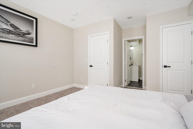 bedroom with connected bathroom and carpet