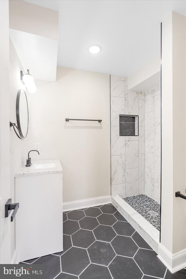 bathroom featuring tiled shower, tile patterned floors, and vanity