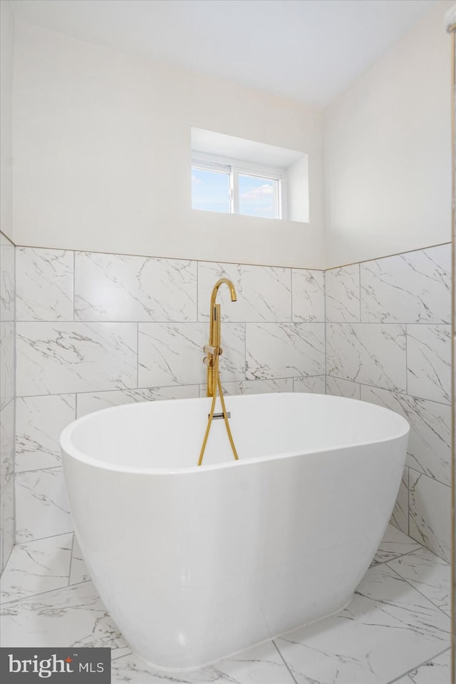 bathroom featuring tile walls and a bathing tub