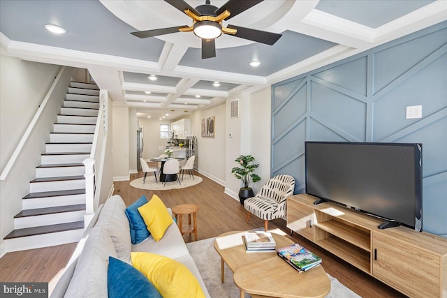 living room with hardwood / wood-style floors, coffered ceiling, ornamental molding, beamed ceiling, and ceiling fan