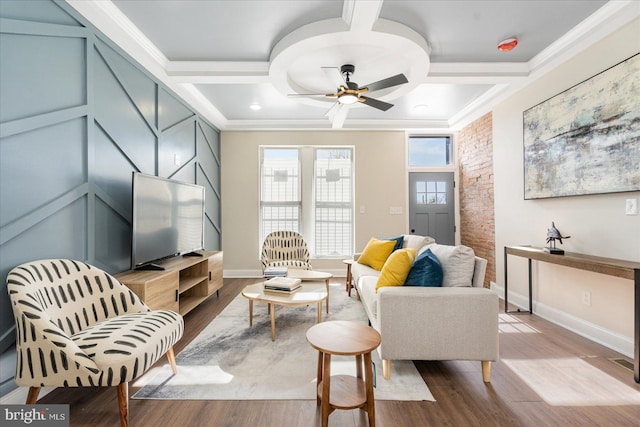 living room with light hardwood / wood-style floors, ceiling fan, coffered ceiling, and ornamental molding