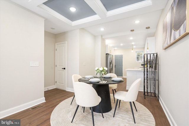 dining space with dark wood-type flooring and ornamental molding