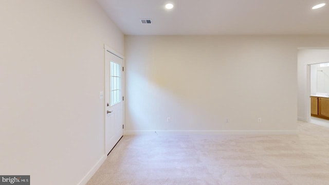 spare room featuring light carpet