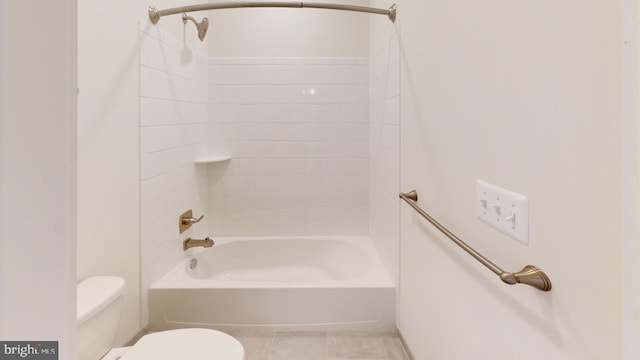 bathroom featuring tiled shower / bath, tile patterned floors, and toilet