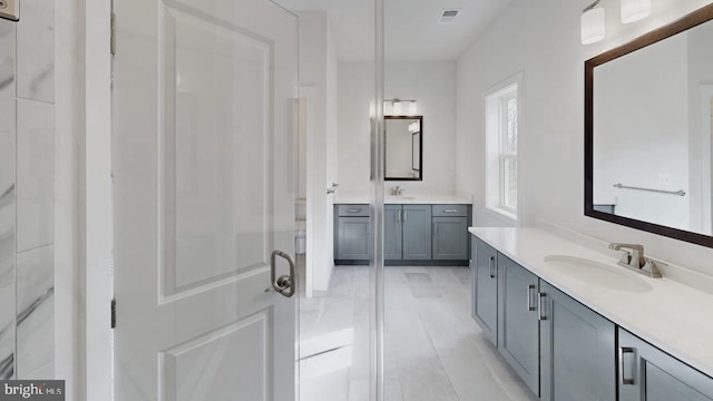 bathroom with tile patterned floors, vanity, and an enclosed shower