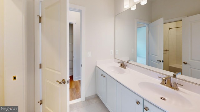 bathroom featuring tile patterned flooring, vanity, and a shower