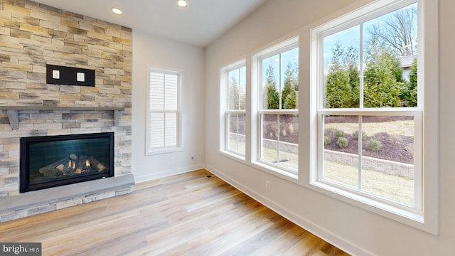 unfurnished living room with light wood-type flooring and a fireplace