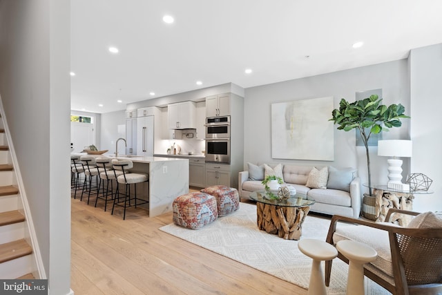 living room with light wood-type flooring and sink