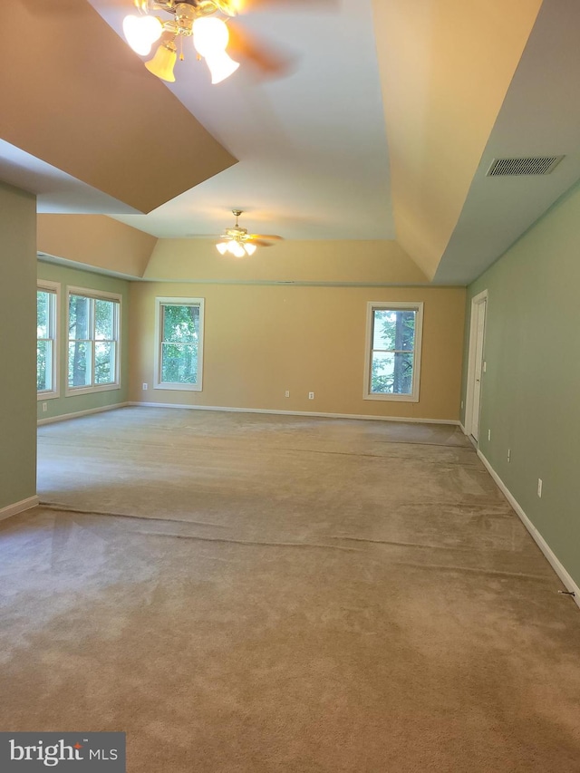 carpeted spare room with a healthy amount of sunlight and ceiling fan