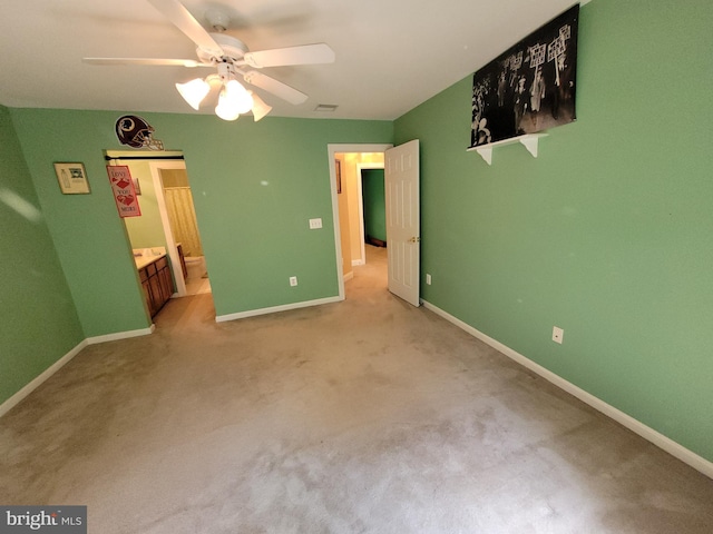 unfurnished bedroom with light carpet, connected bathroom, and ceiling fan