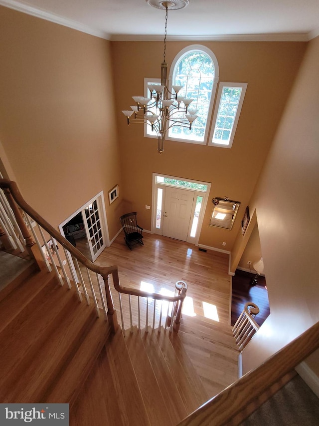 entryway with a chandelier, light hardwood / wood-style flooring, and crown molding