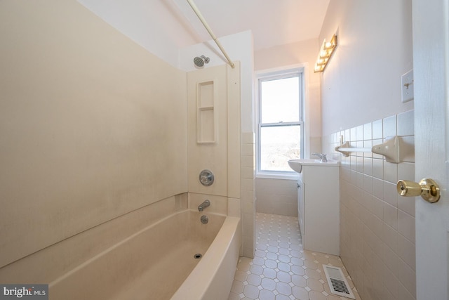 bathroom with tile walls, tile patterned flooring, vanity, and shower / bathing tub combination