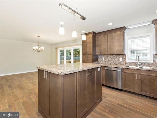 kitchen with stainless steel dishwasher, a chandelier, light hardwood / wood-style flooring, and decorative light fixtures