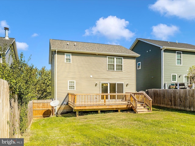 rear view of property featuring a wooden deck and a lawn