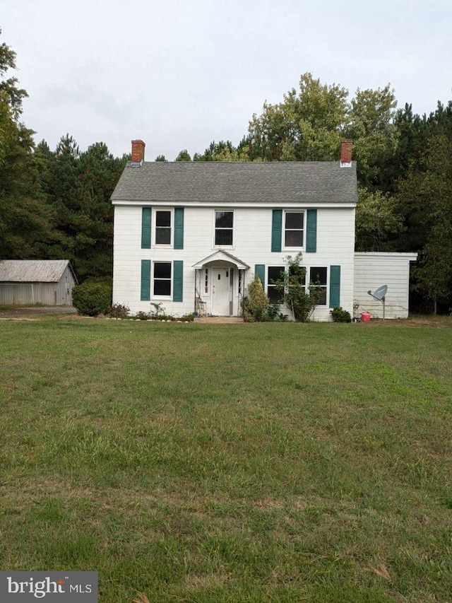 raised ranch with a front lawn and a chimney