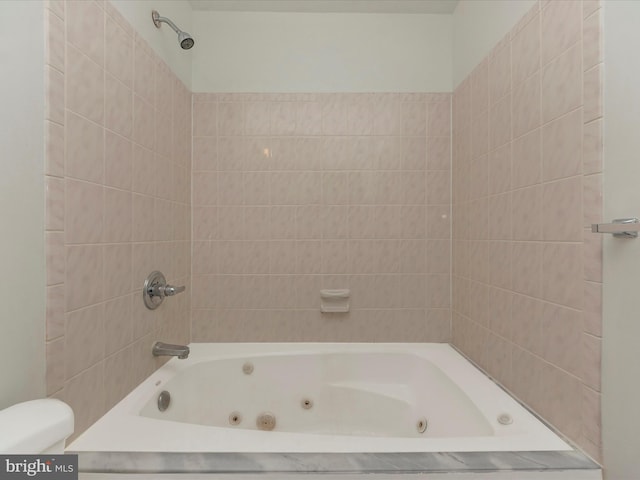 bathroom with toilet and tiled shower / bath combo