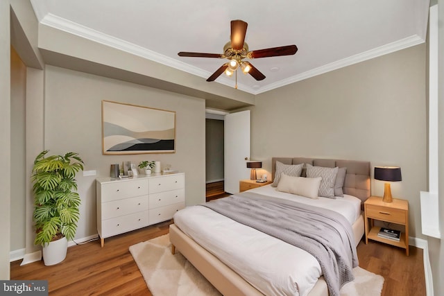 bedroom with dark hardwood / wood-style flooring, crown molding, and ceiling fan