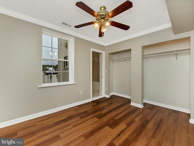 unfurnished bedroom featuring dark hardwood / wood-style flooring, crown molding, two closets, and ceiling fan