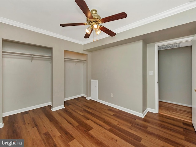 unfurnished bedroom with ornamental molding, two closets, dark hardwood / wood-style floors, and ceiling fan