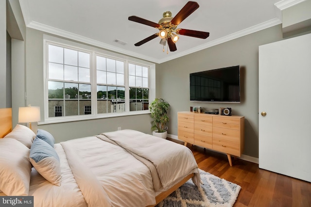 bedroom featuring ceiling fan, ornamental molding, and dark hardwood / wood-style flooring