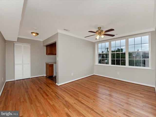 unfurnished living room with ceiling fan, ornamental molding, and light wood-type flooring