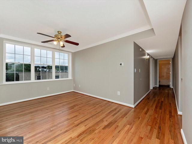 spare room with crown molding, light hardwood / wood-style floors, and ceiling fan