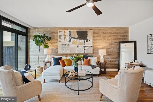 living room with hardwood / wood-style floors, a healthy amount of sunlight, and brick wall