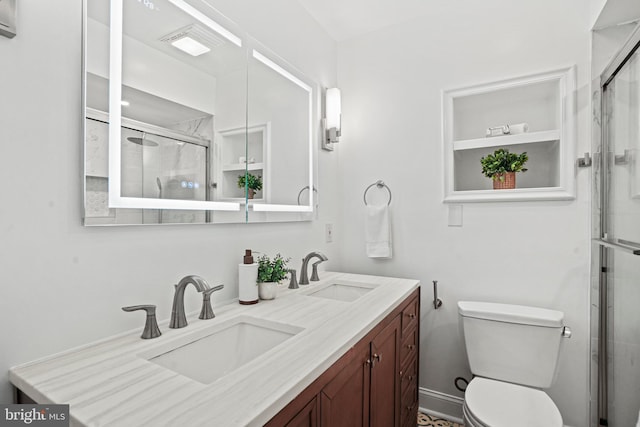 bathroom featuring vanity, toilet, and a shower with door