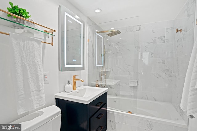 full bathroom featuring tiled shower / bath combo, toilet, and vanity