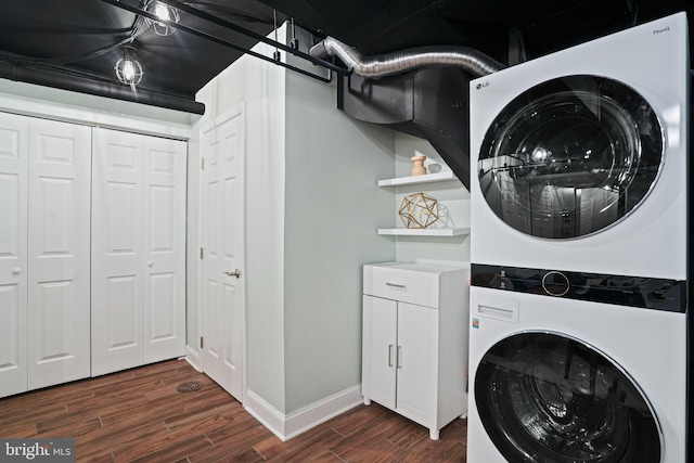 washroom featuring dark hardwood / wood-style flooring, stacked washer and dryer, and cabinets