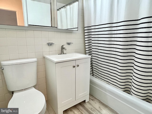 full bathroom with tile walls, vanity, toilet, and hardwood / wood-style flooring