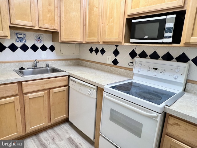 kitchen with light hardwood / wood-style flooring, decorative backsplash, white appliances, and sink