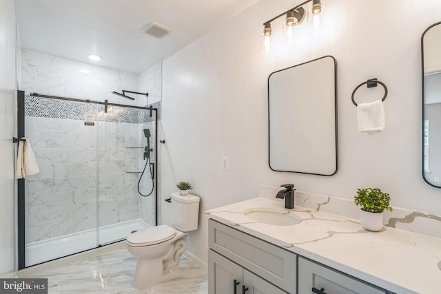 bathroom featuring a tile shower, vanity, and toilet