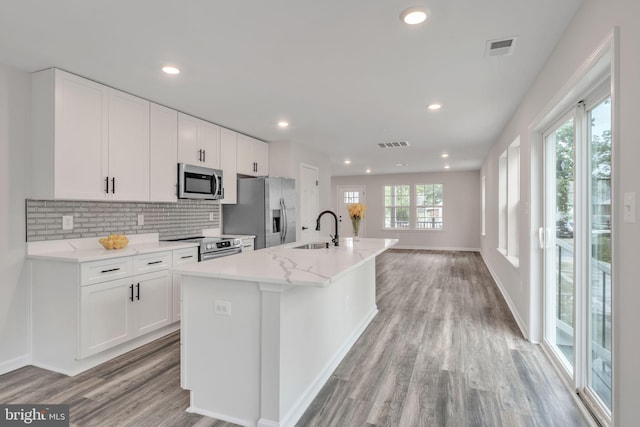 kitchen featuring white cabinets, sink, a kitchen island with sink, stainless steel appliances, and light hardwood / wood-style floors