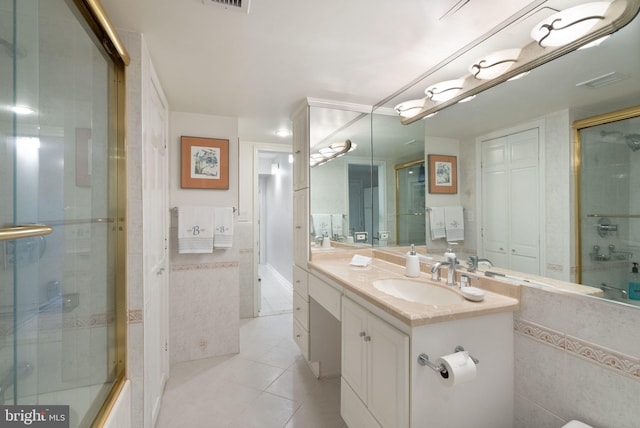 bathroom with tile patterned flooring, vanity, and a shower with shower door