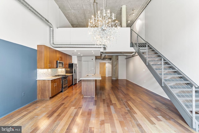 kitchen with light hardwood / wood-style flooring, a notable chandelier, appliances with stainless steel finishes, and sink