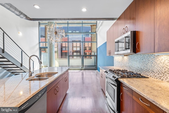 kitchen featuring light stone counters, sink, tasteful backsplash, stainless steel appliances, and dark hardwood / wood-style flooring