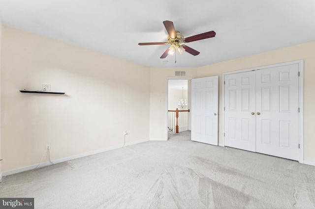 unfurnished bedroom with ceiling fan, light colored carpet, and a closet