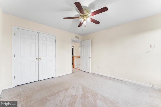 unfurnished bedroom with light carpet, a closet, and ceiling fan