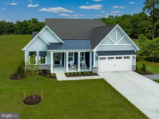 view of front of house with a front lawn, covered porch, and a garage