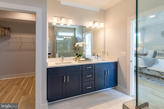 bathroom featuring walk in shower, vanity, and hardwood / wood-style flooring