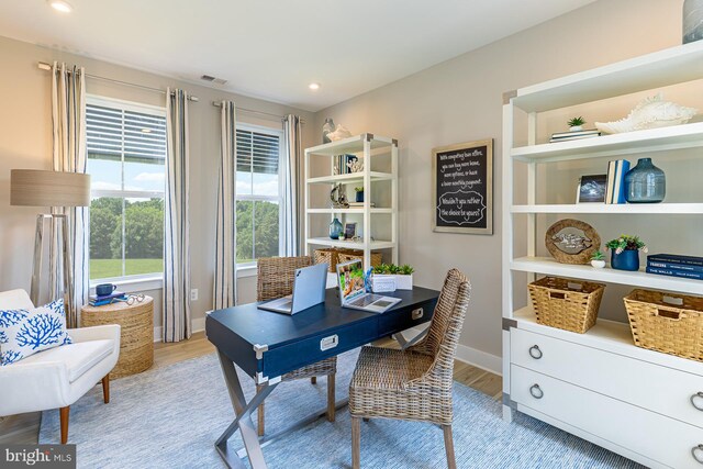 home office with light hardwood / wood-style flooring