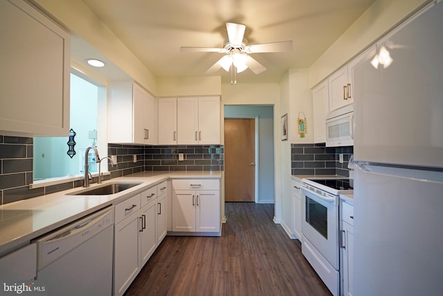 kitchen with sink, white cabinets, dark hardwood / wood-style floors, and white appliances