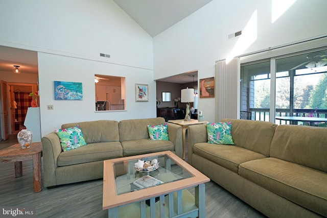 living room with hardwood / wood-style floors, high vaulted ceiling, and ceiling fan