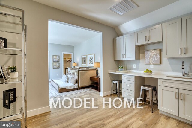 kitchen featuring white cabinetry, sink, and light hardwood / wood-style flooring