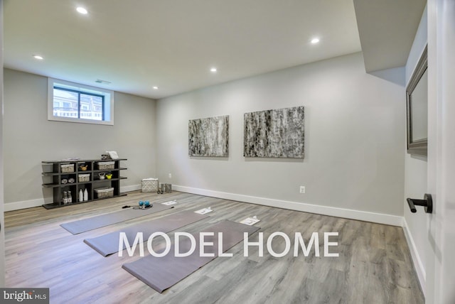 workout area with light hardwood / wood-style flooring